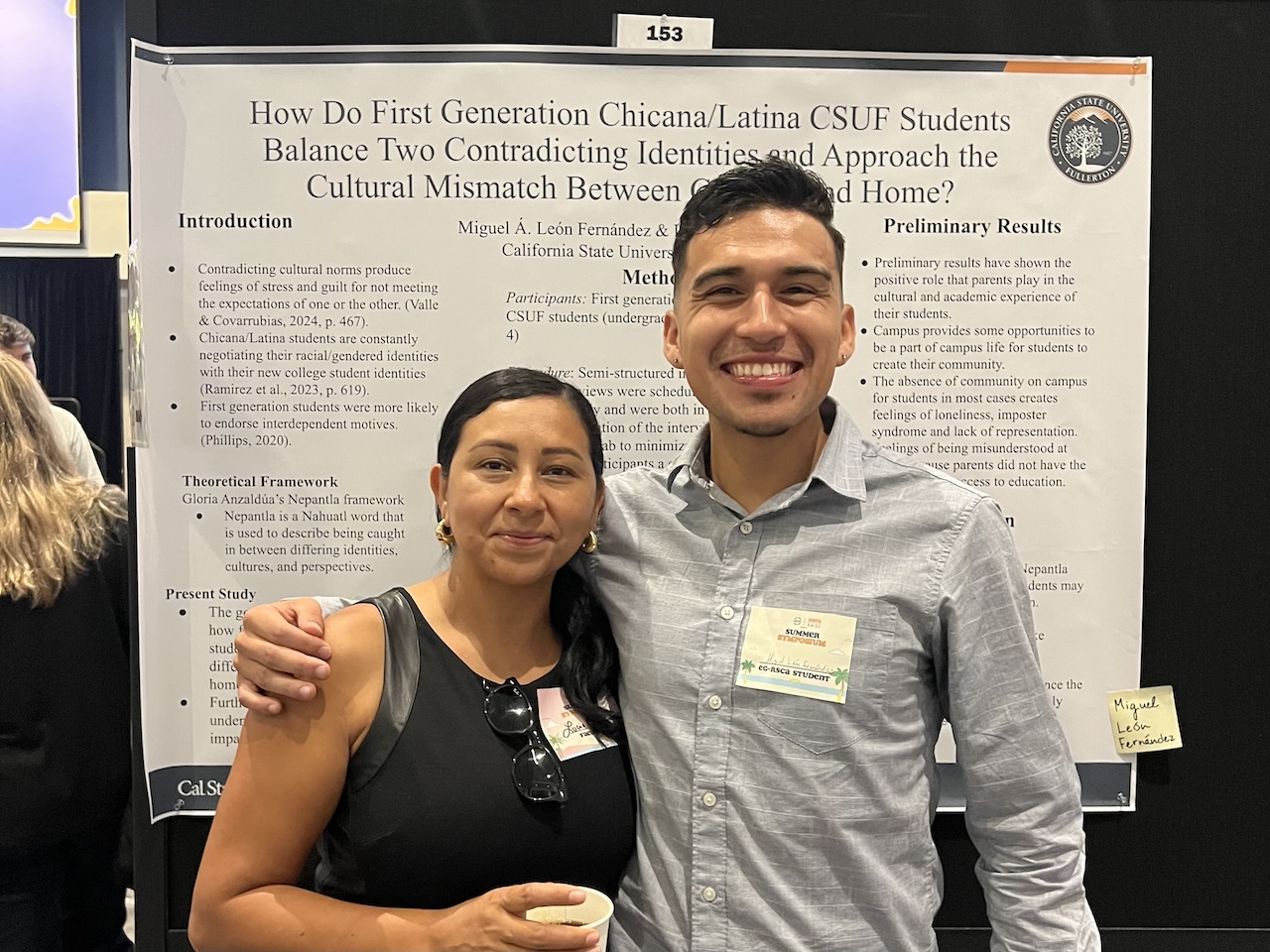 Dr. Lucia Alcala with student standing in front of research poster board